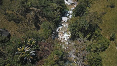 drone vista aérea de pájaro de un río con enormes rocas y agua que fluye en colombia