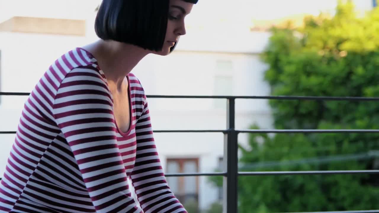 발코니 4k에서 노트북을 사용하는 여성