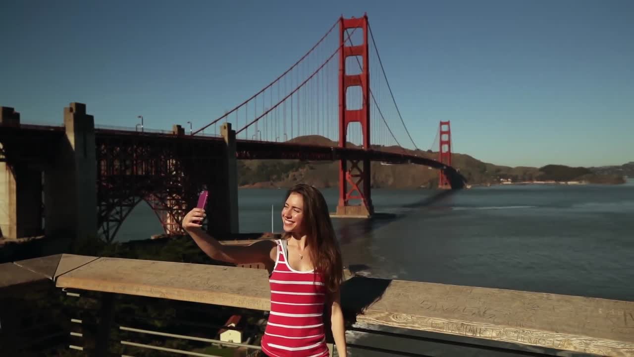 mujer tomando una selfie con el puente golden gate