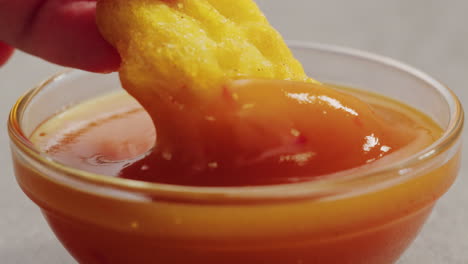 dipping chicken nuggets in sauce