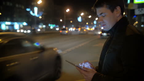 hombre usando el touch pad por el camino ocupado en la ciudad
