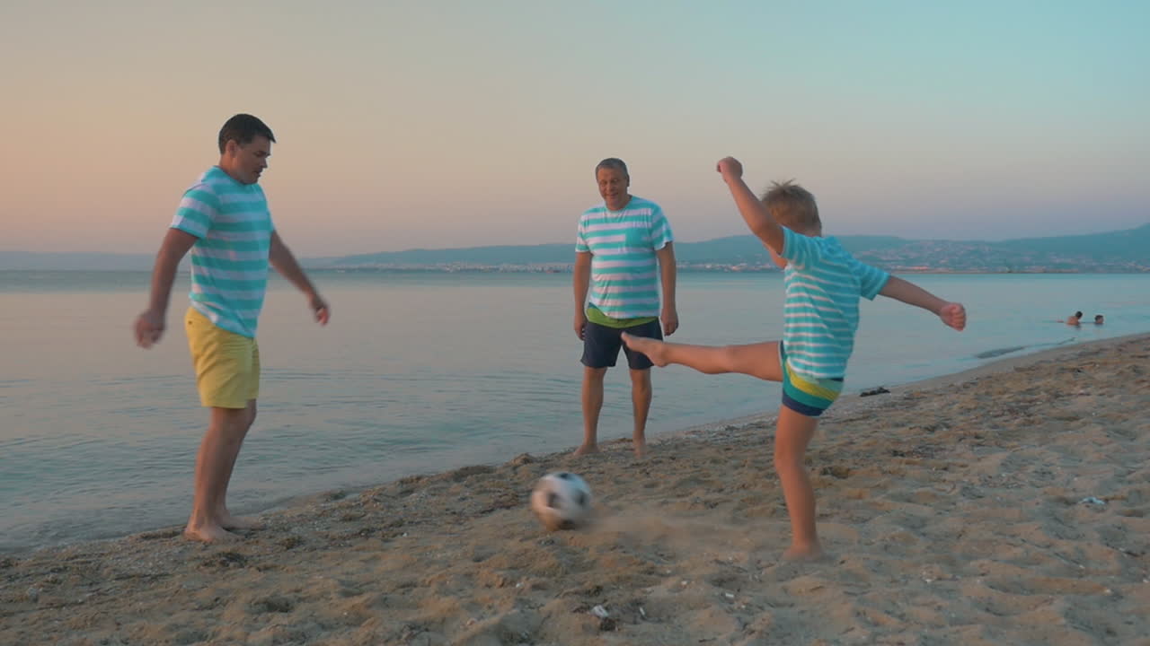 hombres y niños jugando al fútbol en la playa