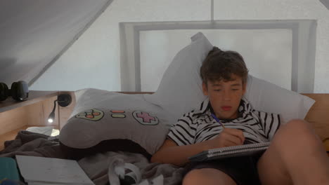 boy doing homework in his cozy bed