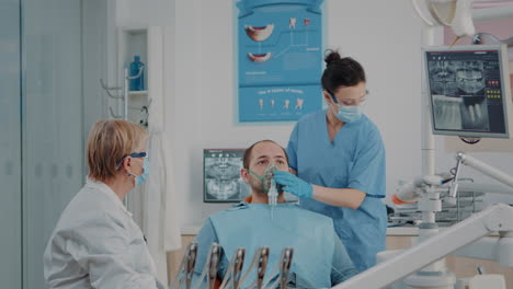 Dentistry-nurse-doing-anesthesia-with-oxygen-mask-on-patient