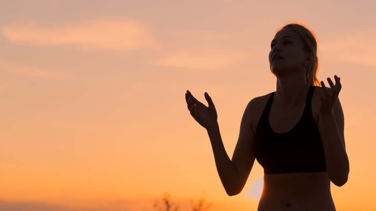 Athletic girl playing beach volleyball jumps in the air and strikes the ball over the net on a beautiful summer evening. Caucasian woman score a point.