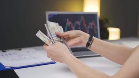 el inversor mira el gráfico de criptografía y cuenta el dinero.