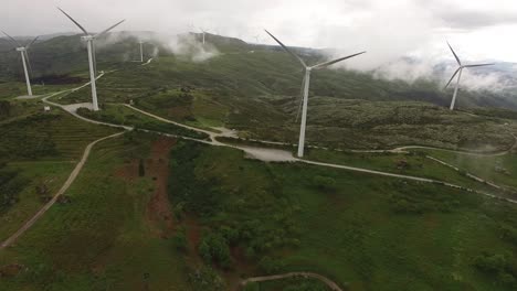 aerial drone of wind farm wind turbines in fog and clouds