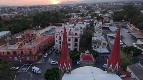 aerial view capturing cuernavaca city in morelos, mexico, featuring calvario church along with bustling streets, diverse buildings, vehicles, and lush vegetation in the vibrant urban landscape
