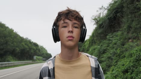 teenager walking outdoors with headphones