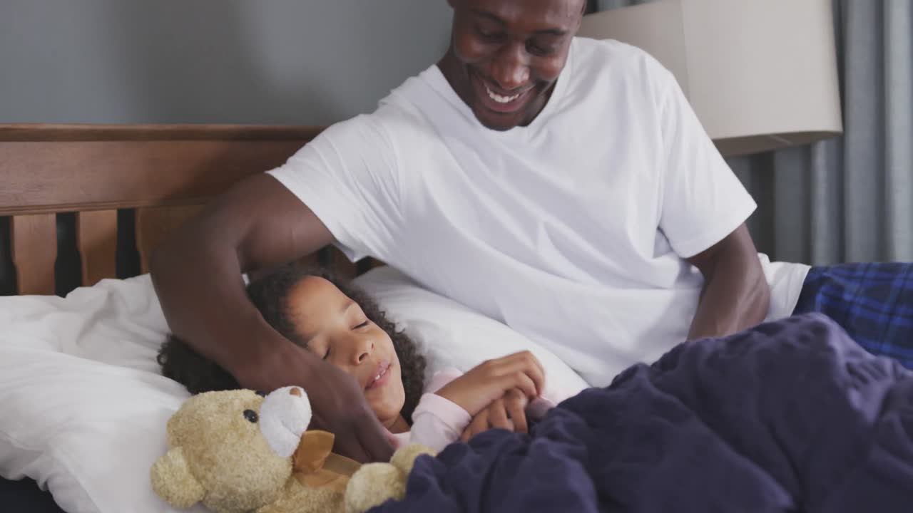 African american father waking up his daughter and laughing