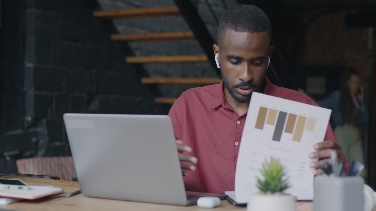 Man working on laptop and design documents