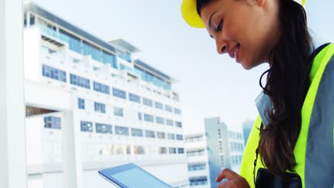 engineer-using-tablet-computer-and-looking-at-building