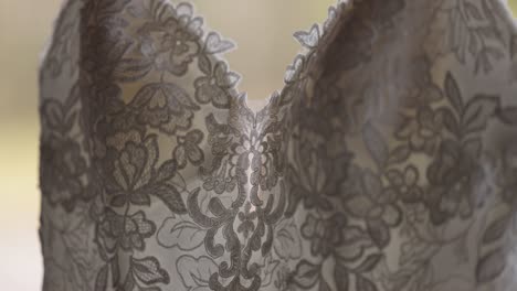 close up details of the chest of a glamourous wedding gown hanging outside on a fall day