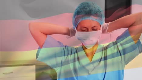 Animation-of-flag-of-germany-waving-over-female-doctor-in-hospital
