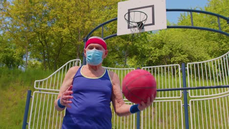 elderly man playing basketball on a court wearing a face mask