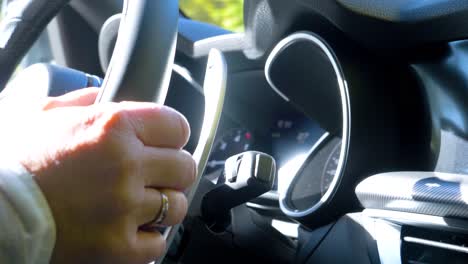 man driving a car and using the steering wheel on a sunny day