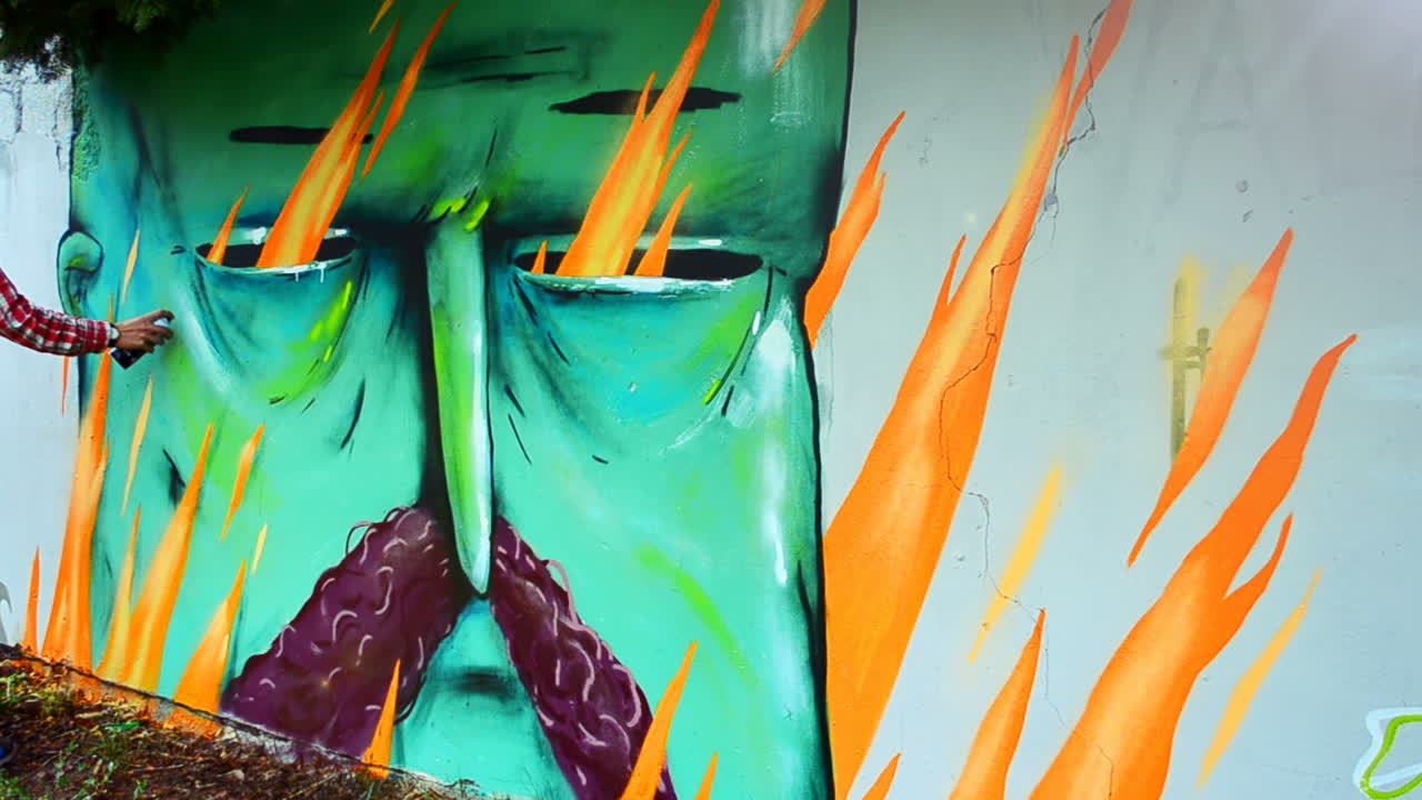 L'artista realizza graffiti su una recinzione. Disegno astratto