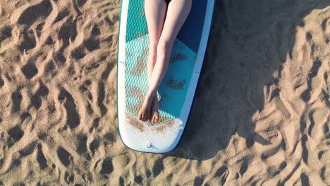 woman laying on surf board at beach