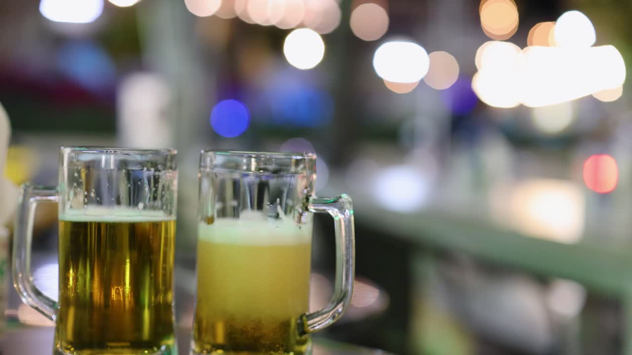 dos tazas de cerveza sonando juntas durante la celebración nocturna