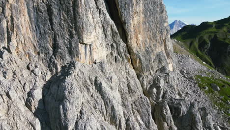 aerial orbit of sharp rocky terrain on the ridge of the dolomites mountain range in italy on sunny summer day