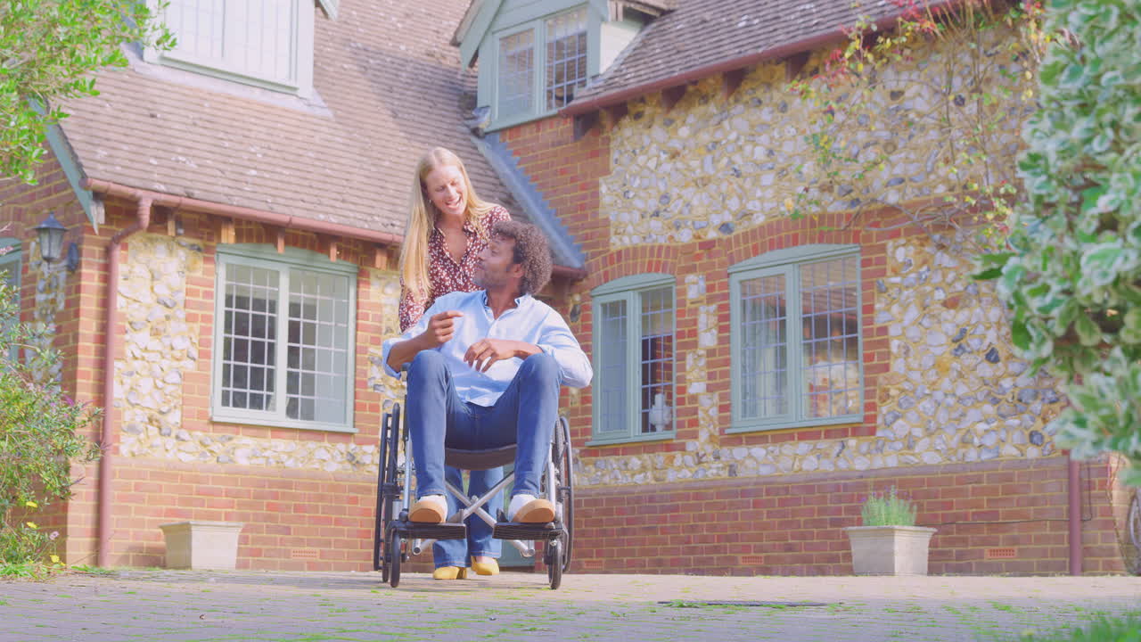 ⁇ 체어 에 앉아 있는 남자 와 함께 미소 짓는 성숙 한 부부 가 집 밖 에 있는 여자 에 의해 밀려들고 있다