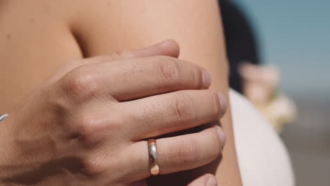 un hombre amoroso con anillo de bodas abraza a su esposa joven en un día de verano