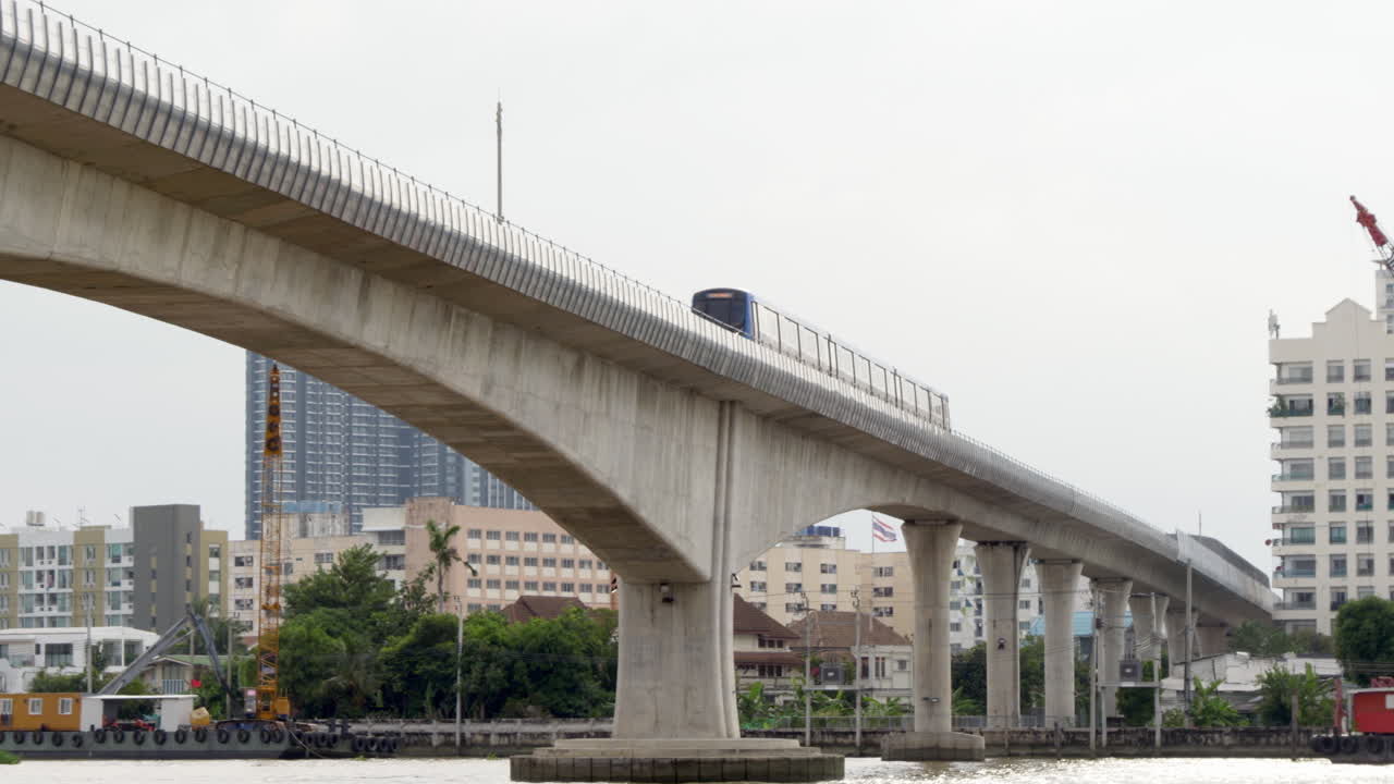 Blue Line MRT Train on the Bridge Over Chao Phraya River at Bang Pho Station, Connecting Both Sides of Bangkok for Efficient and Environmentally Friendly Transportation Across the City
