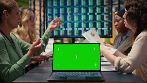 team of businesswomen creates a strategy next to chroma key display