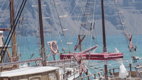 Fishing-boat,-cabin,-ropes,-docked,-floating,-rocking,-ocean,-sea,-cliff,-Oia,-close-up,-Santorini,-Islands,-Greece