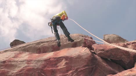 male climber dropping down quickly from a vertical rock