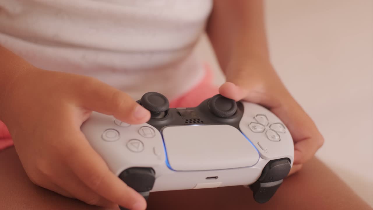 A person holding a Playstation 5 controller
