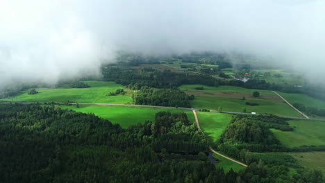 Birds-eye-view-showing-thick-cover-of-fog-and-mist-in-atmosphere-over-green-piece-of-countryside-land