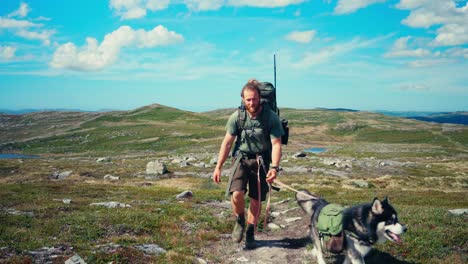 Trekking-An-Sonnigen-Tagen-Mit-Kaukasischem-Kerl-Und-Alaskan-Malamute-Hunderasse