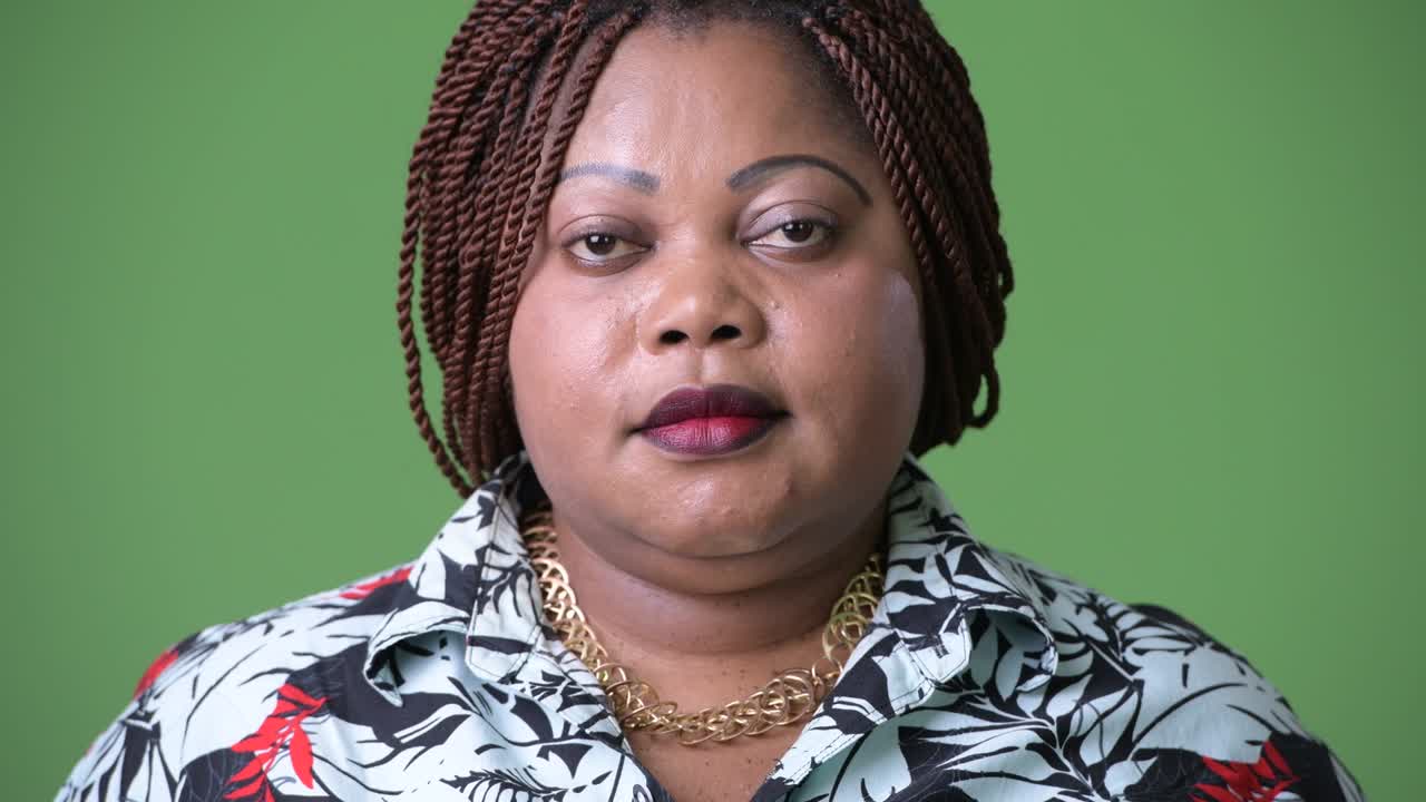mujer africana hermosa con sobrepeso contra un fondo verde