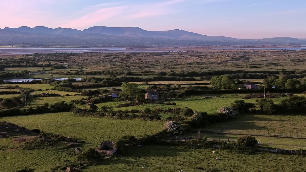 Idyllic Welsh meadow under Snowdonia mountains aerial circling view across rural Eryri national park