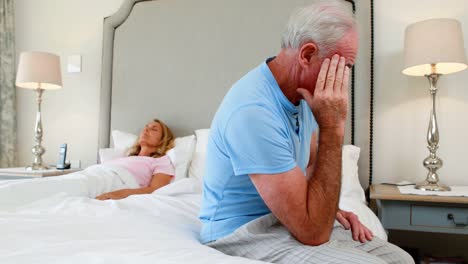 Worried-senior-man-sitting-in-bedroom