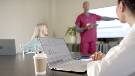 Diverse-doctors-using-laptops-in-meeting-room-with-copy-space,-slow-motion