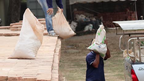 workers tossing and catching a heavy bag outdoors