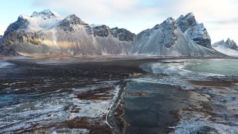 playa de arena negra reynisfjara en islandia con amanecer durante el invierno