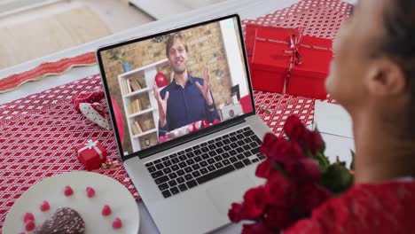 Verschiedenes-Paar-Bei-Einem-Valentinstag-Videoanruf,-Mann-Auf-Dem-Bildschirm,-Der-Mit-Einer-Frau-Spricht,-Die-Blumen-Hält