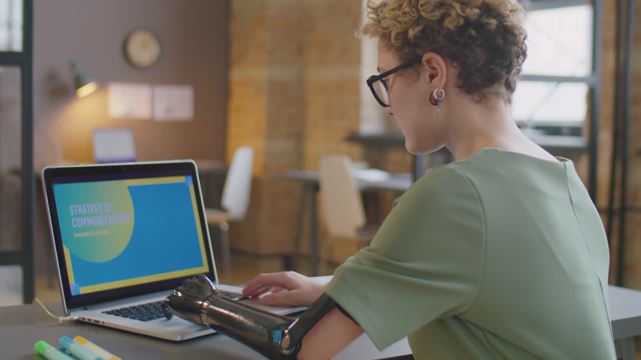 Businesswoman with Prosthetic Arm Working on Presentation on Laptop