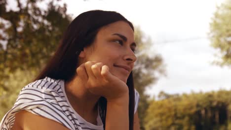 Pretty-brunette-thinking--in-park