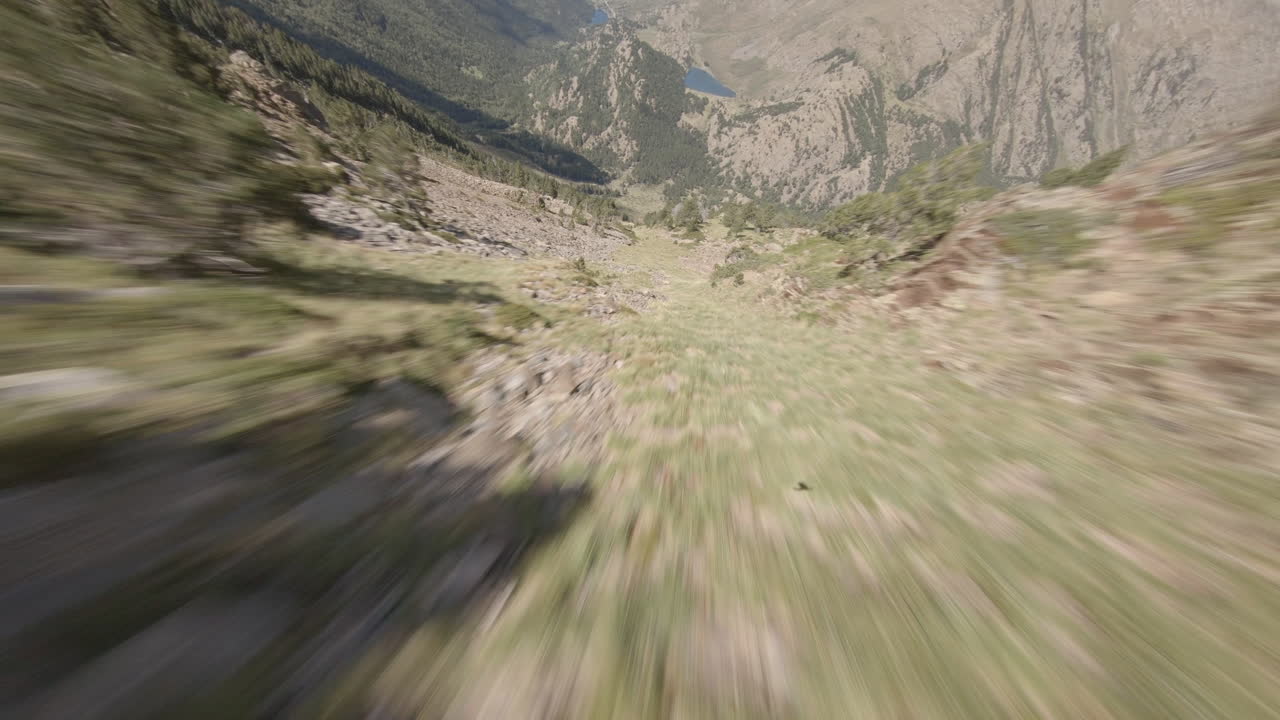 dron deportivo extremo fpv volando rápido por la montaña rocosa en puymorens, adelante
