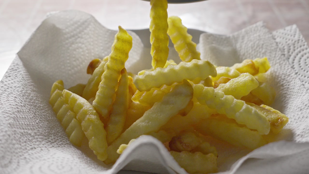 Close up of crinkle fries served on absorbent paper