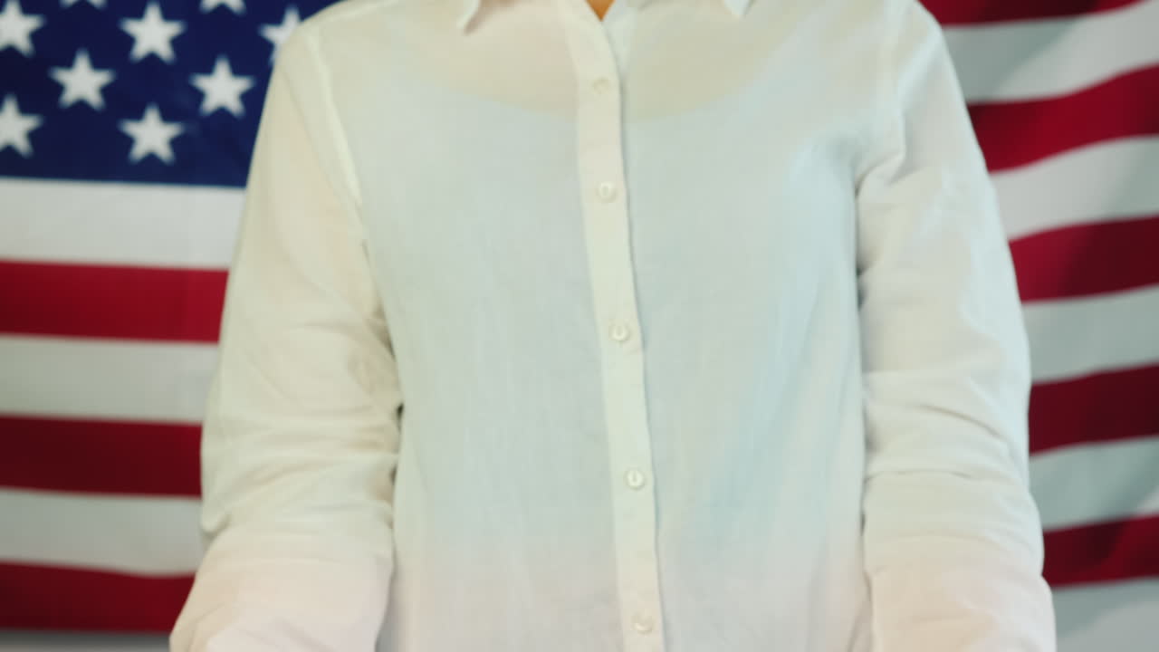 의료용 마스크를 쓴 여성이 미국 국기 배경에 물음표가 있는 포스터를 들고 있다