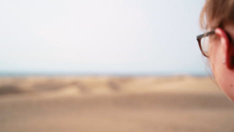 Young-girl-enjoying-beautiful-view-of-sandy-desert,-dunes-and-ocean-water-in-Gran-Canaria,Spain