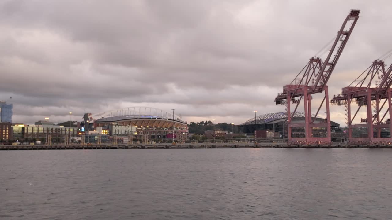 Gimbal wide panning shot of the Port of Seattle with Lumen Field and T-Mobile Park as seen from a moving boat on Elliott Bay in Seattle, Washington. 4K at 30 FPS