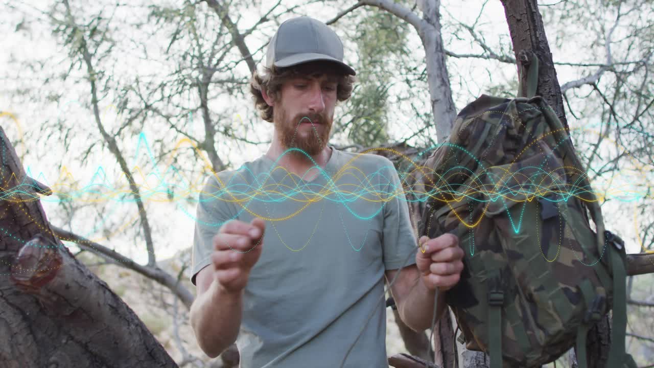 Un appassionato di outdoor recupera del paracord da uno zaino mimetico e misura la lunghezza della corda per la sopravvivenza.