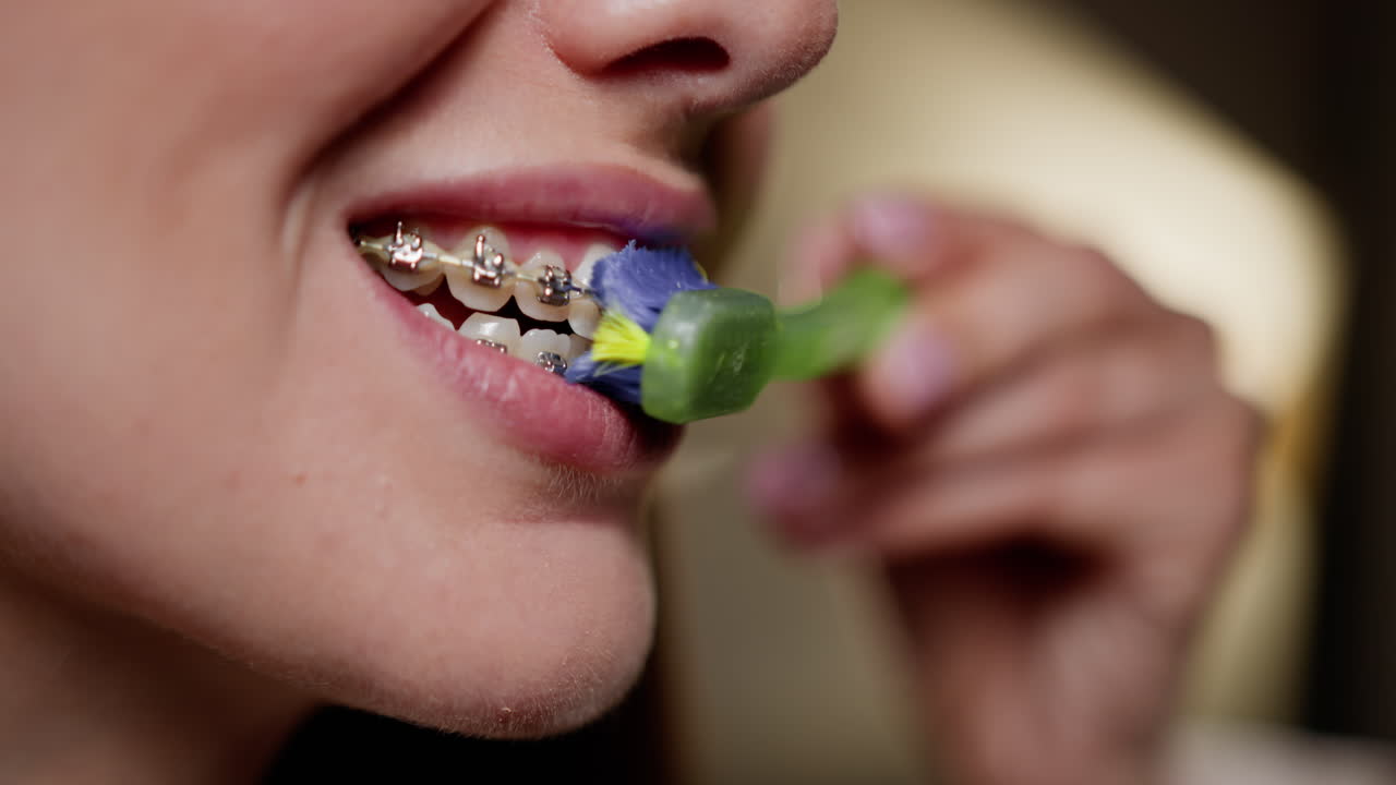 Woman with braces brushing her teeth