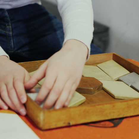 boy playing with puzzle wooden tangram. early education concept square video